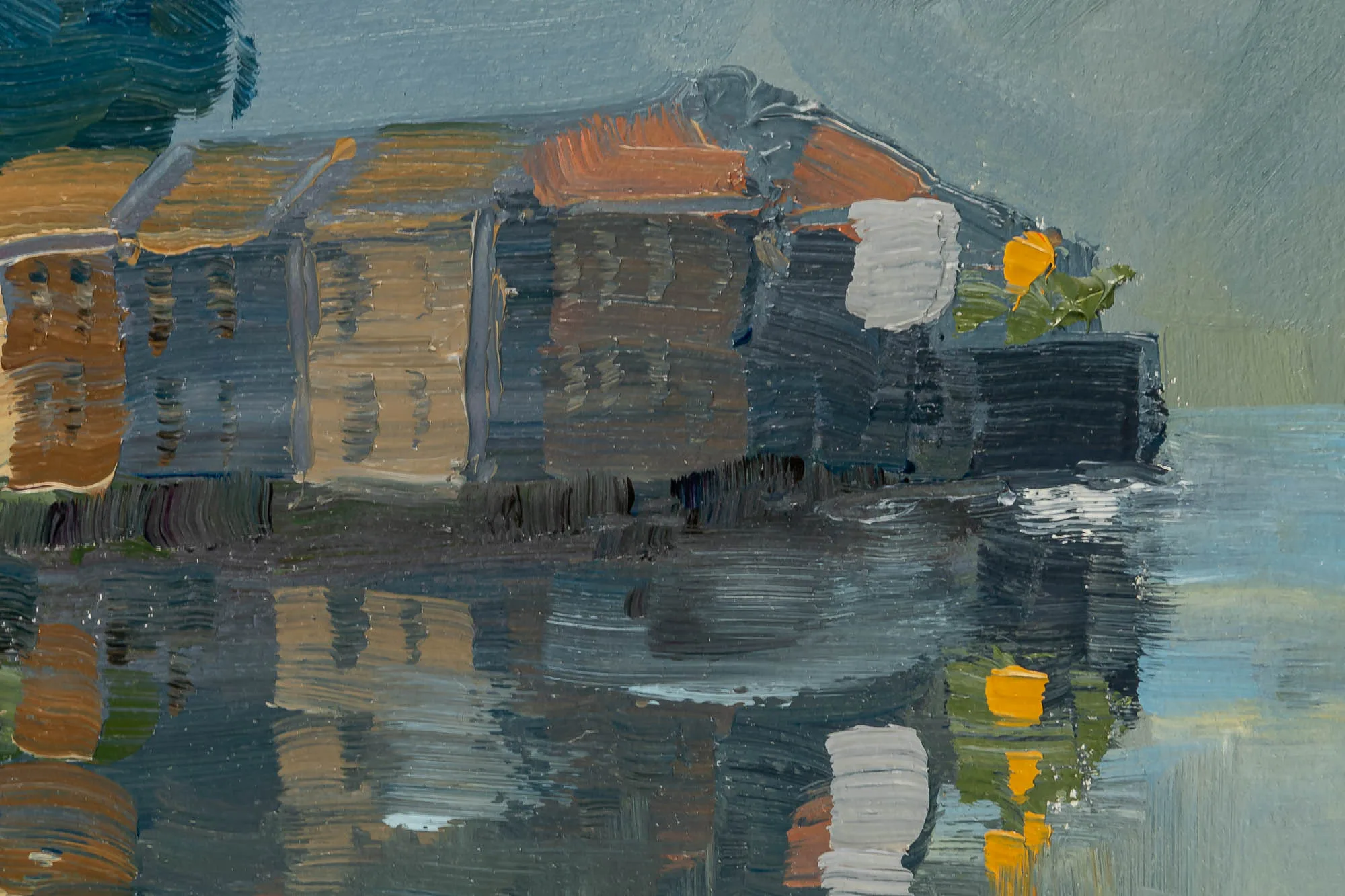 Close-up of Lakeside Tranquility, an original oil on paper painting by Paul Kenton, showing thick brushstrokes of ochre, slate and orange on a lakeside building and its reflection in still water.