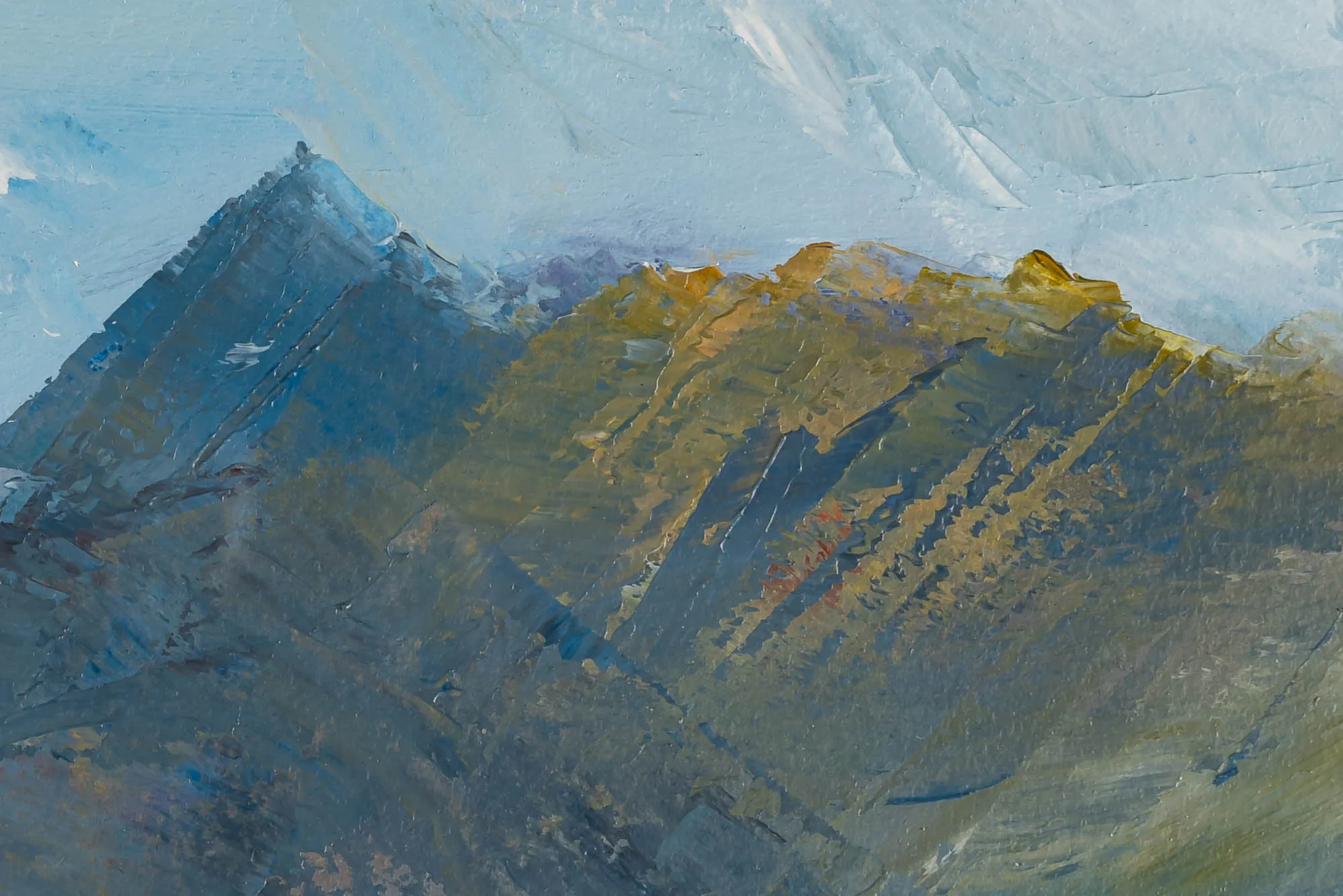 Close-up of Serene Expanse, an original oil on paper painting by Paul Kenton, showing thick textured brushstrokes of blue-grey peaks catching warm ochre light against a pale sky.