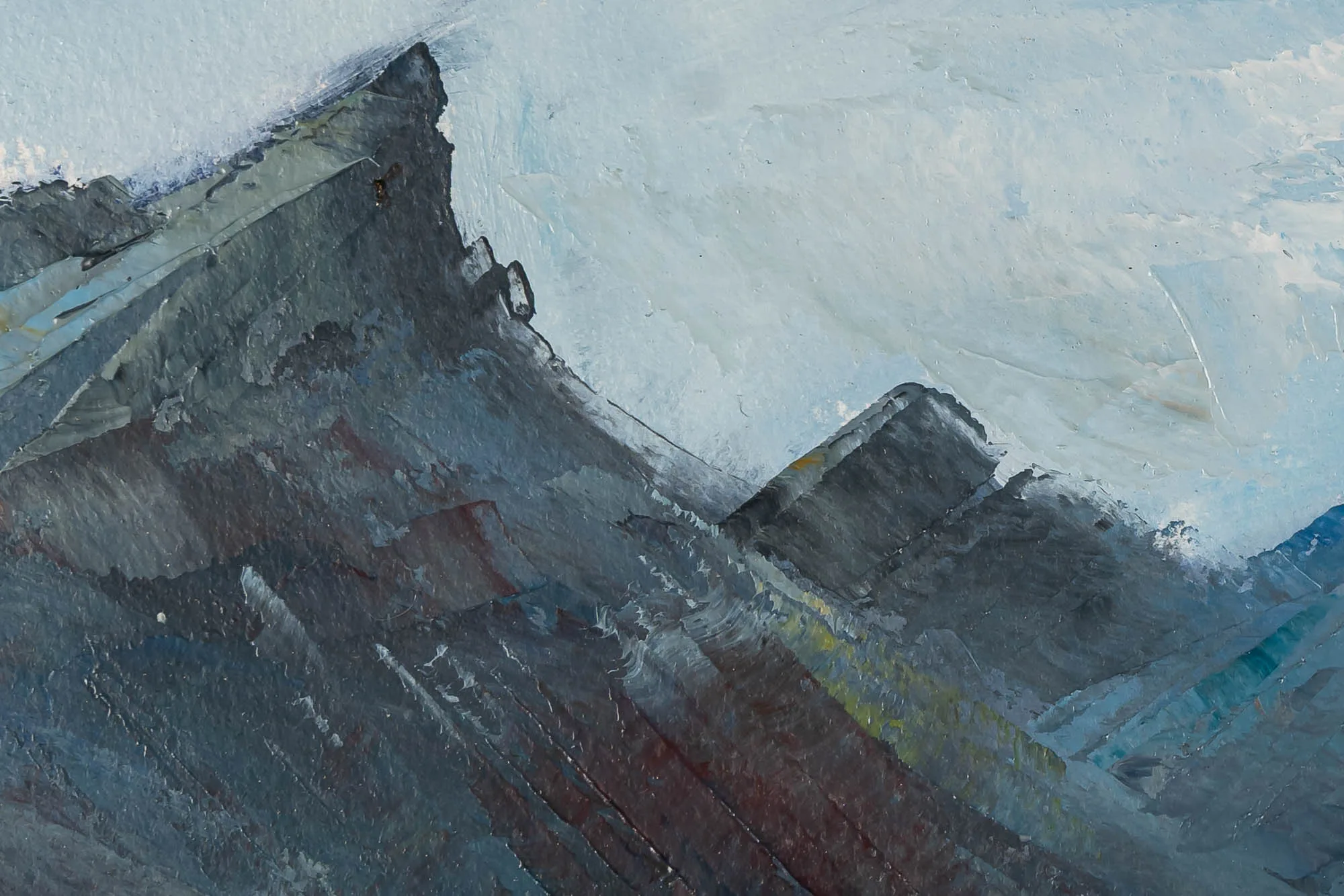 Close-up of Serene Expanse, an original oil on paper painting by Paul Kenton, showing thick textured brushwork on jagged grey and slate-blue mountain ridges beneath a pale, misty sky.
