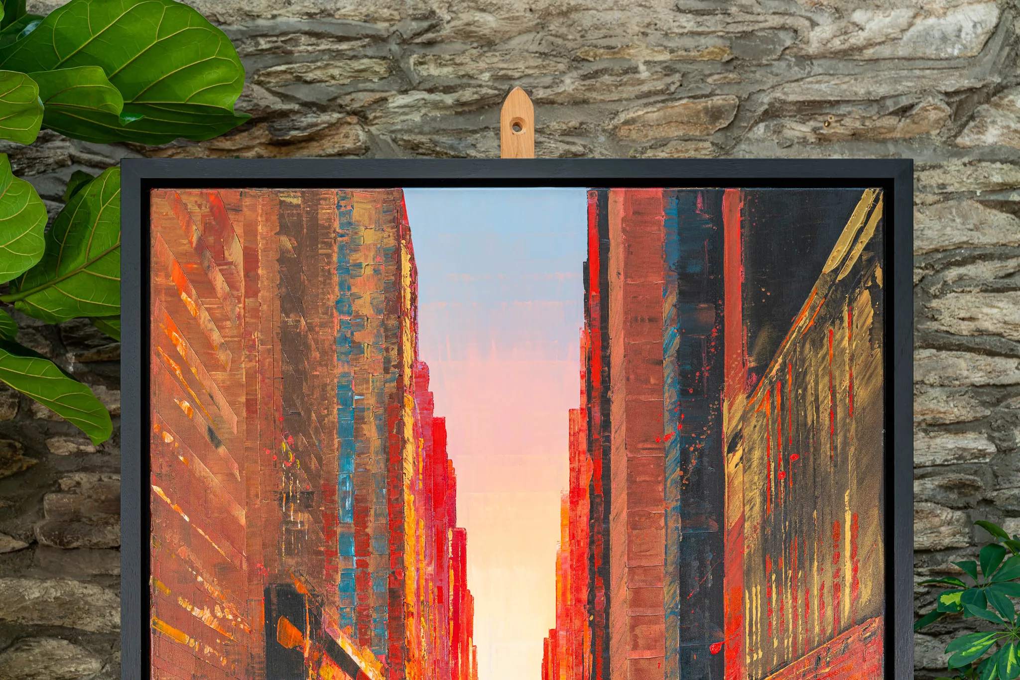 Close-up of Big Apple Dreaming, an original mixed media painting by Paul Kenton: a narrow New York street of textured red and ochre buildings opens to a pale pink and blue sky, with metallic accents.