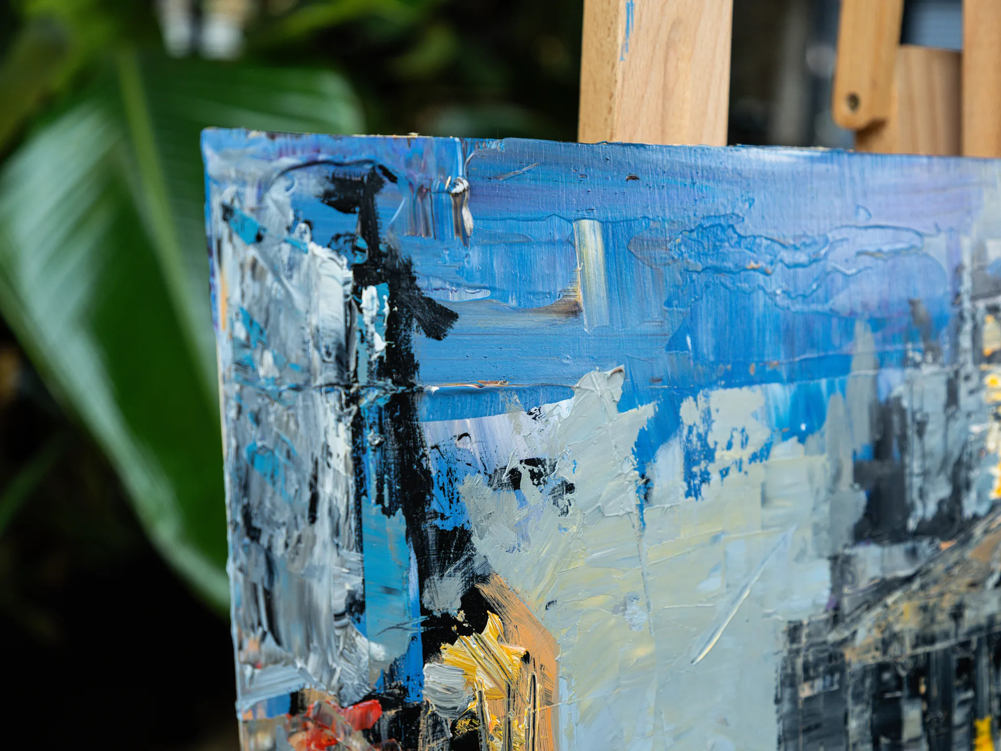 Close-up of Bank Junction, an original mixed media painting by Paul Kenton, showing thick blue, white and black brushstrokes with flecks of orange and red on a city scene.