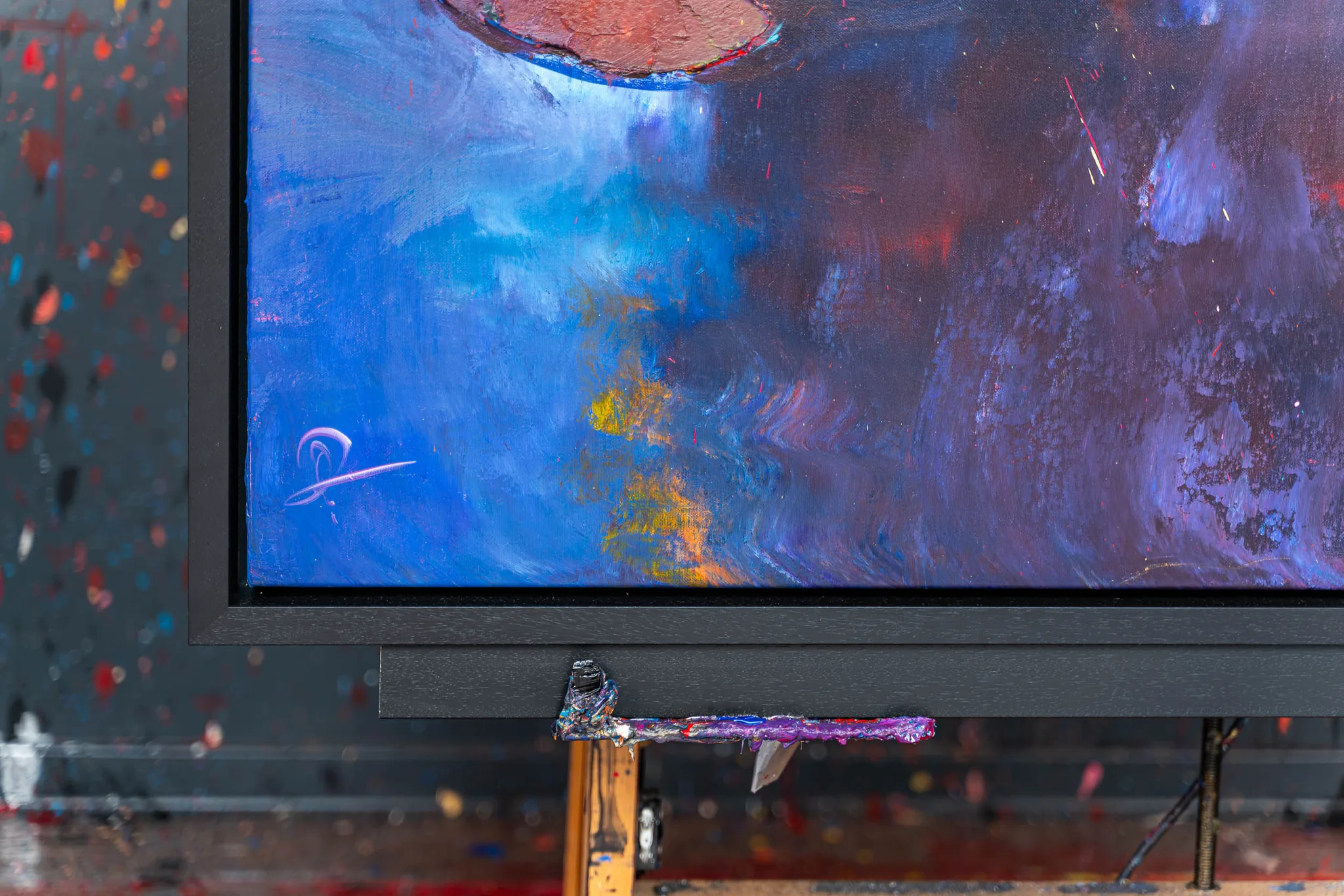 Close-up of Celestial Blooms, an original painting by Paul Kenton, showing thick, textured strokes of blue, violet and deep red with flecks of gold and a pale signature in the lower left corner.