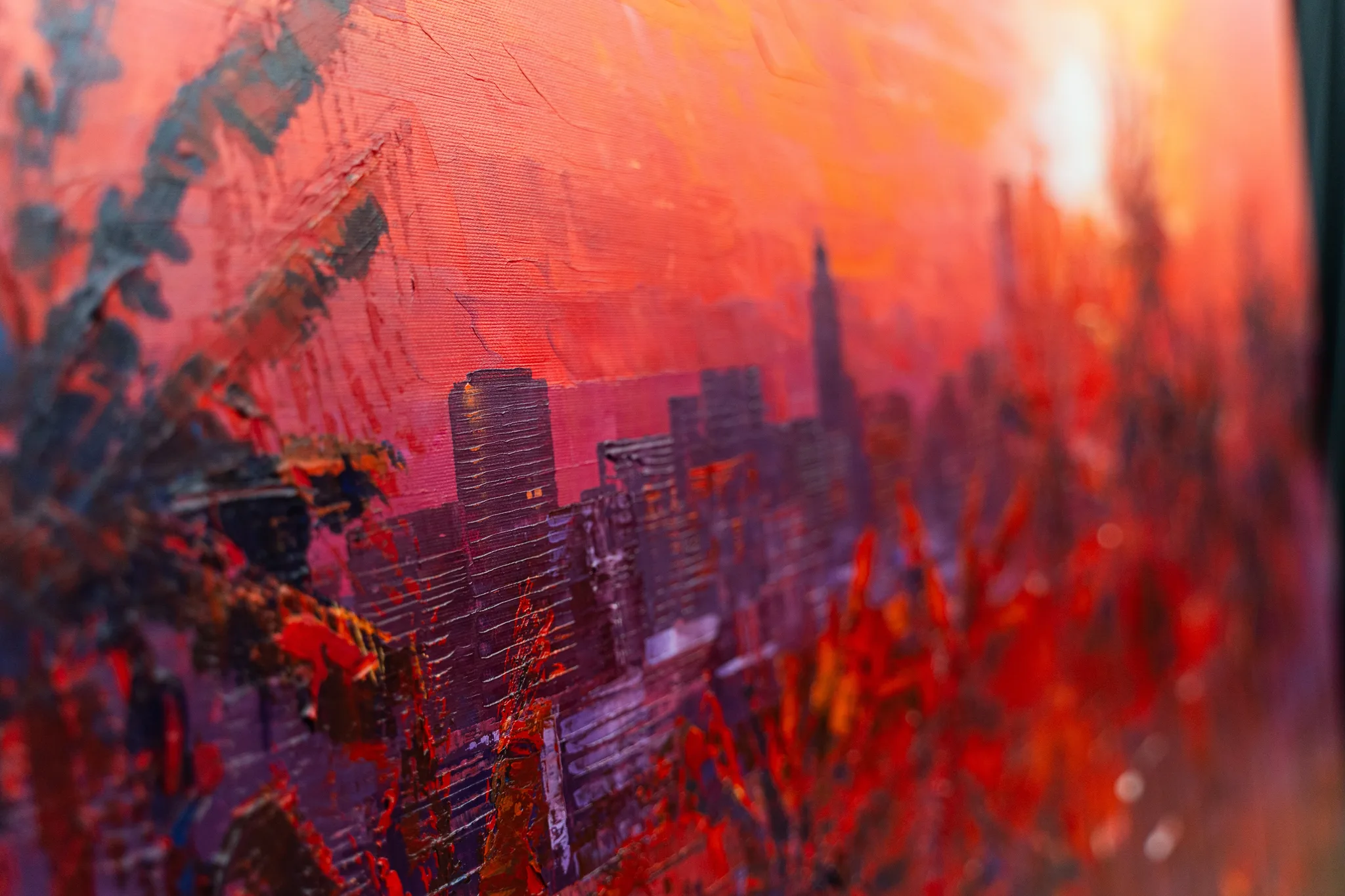 Close-up of City Beyond the Palms, an original painting by Paul Kenton, showing thick red and orange impasto brushstrokes and a blurred skyline of tall towers beneath a fiery sunset.