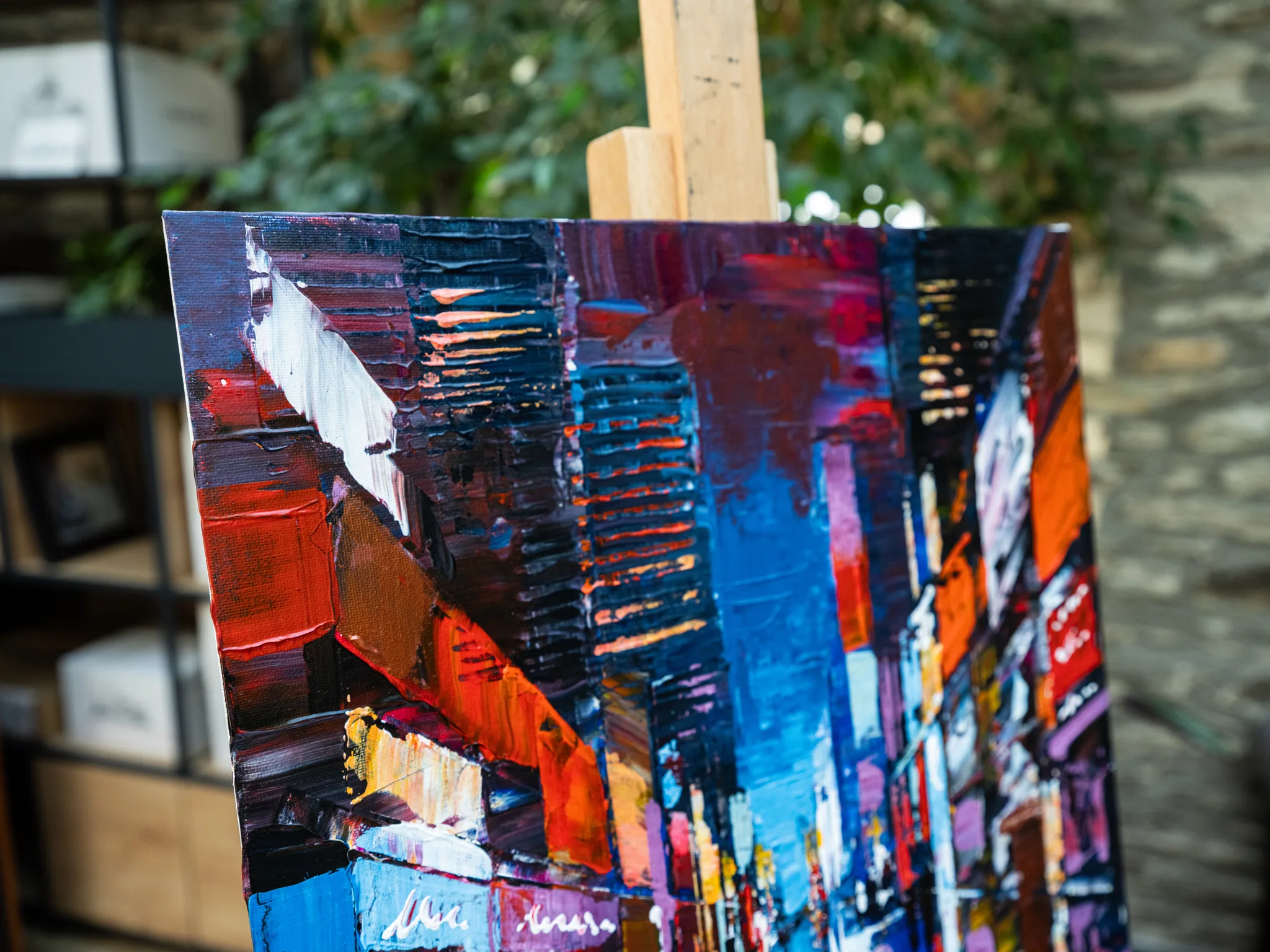 Close-up of City Corridor, an original painting by Paul Kenton, showing thick palette-knife strokes of red, orange, blue and black forming tall buildings and a street of New York.