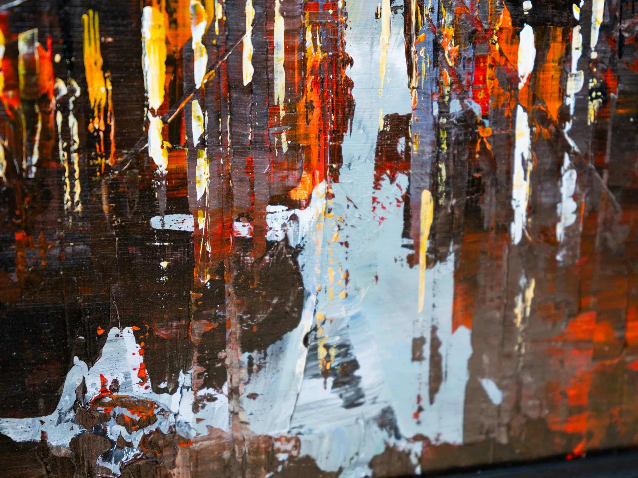 Close-up detail of Dark Midtown, an original painting by Paul Kenton: thick, textured strokes of white, yellow and red drip over deep brown and black, suggesting city lights at night.
