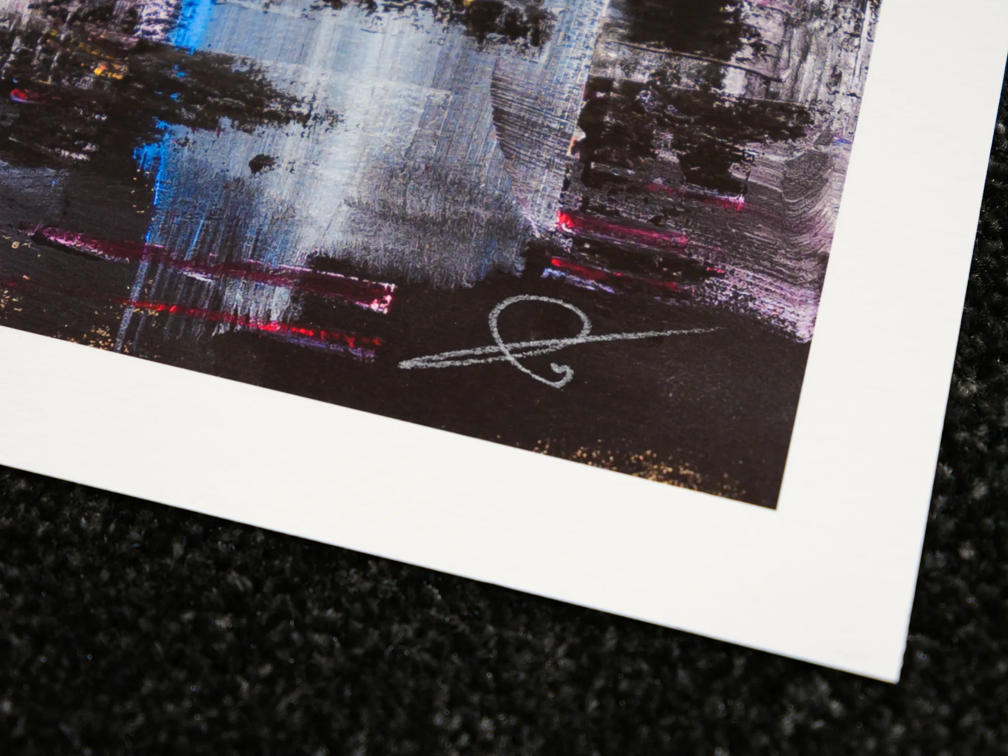 Close-up of the lower corner of Empire State Power, a limited edition print by Paul Kenton, showing textured streaks of blue, red and silver over dark paper and his signature in white pencil.