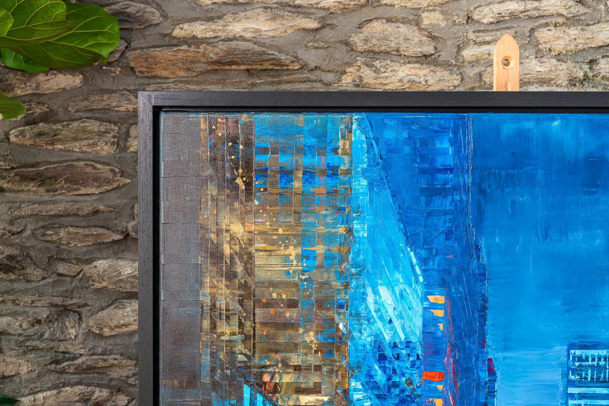 Close-up of Feeling Groovy, an original mixed media painting by Paul Kenton, showing textured blue cityscape towers with gold metallic flecks and orange lights, edged by a dark frame.