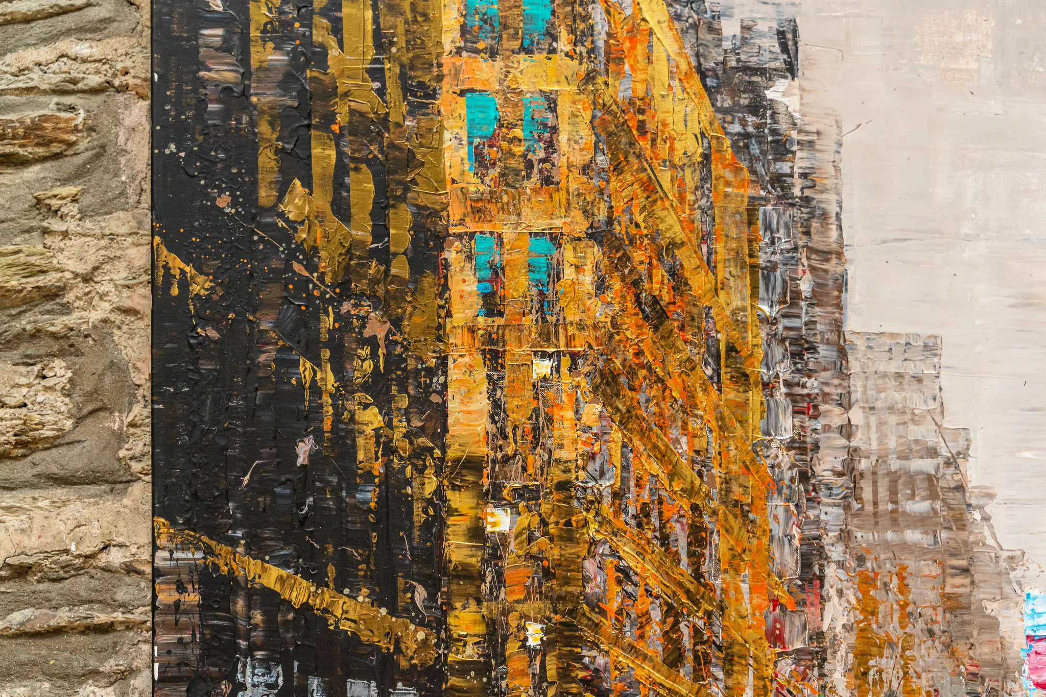 Close-up of Golden Metropolis, an original mixed media painting by Paul Kenton, showing thick gold, orange and black palette-knife strokes forming towering New York buildings, with teal windows and a pale sky.