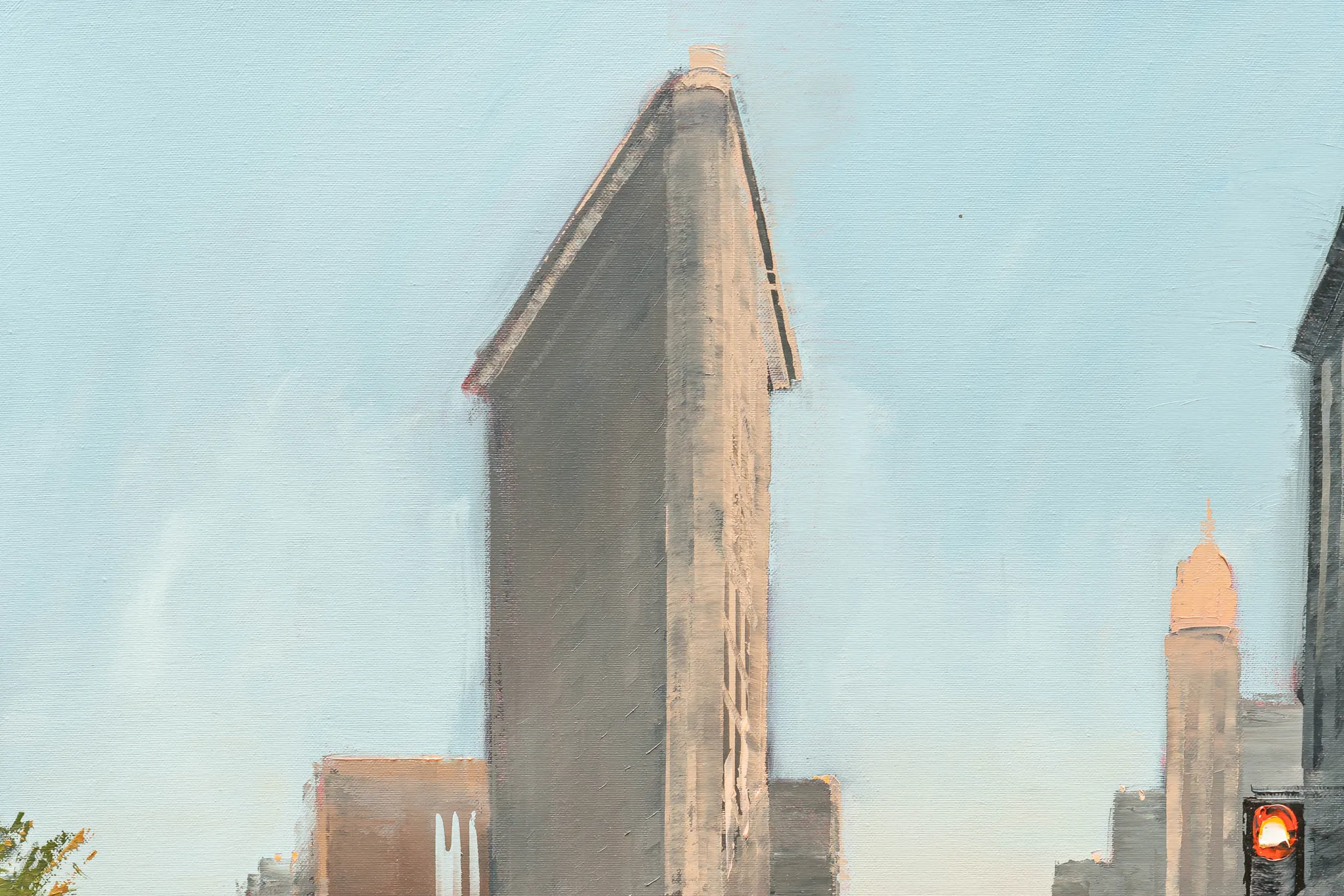 Detail of Muted Manhattan, an original oil painting by Paul Kenton: the wedge-shaped Flatiron Building rises against a pale blue sky, with soft grey and peach-toned buildings and a small red traffic light.