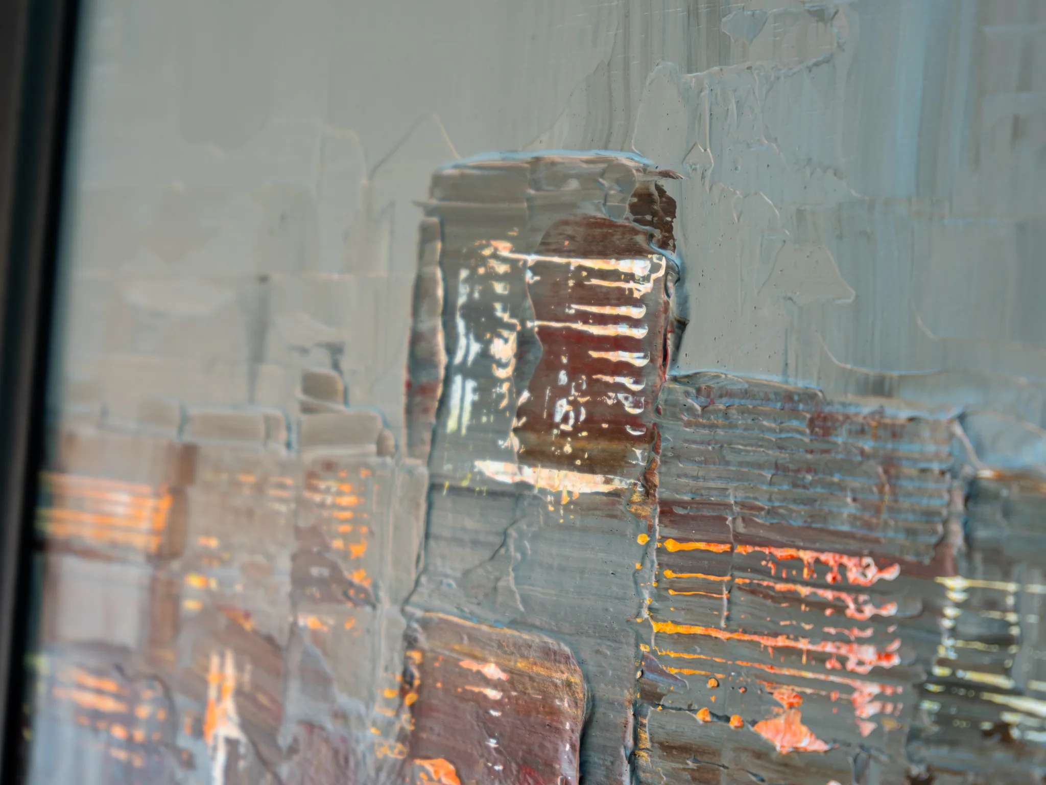 Close-up of Midtown Silver, an original painting by Paul Kenton, showing thick palette-knife texture of grey and silver paint with rust-brown blocks and orange highlights suggesting city towers.