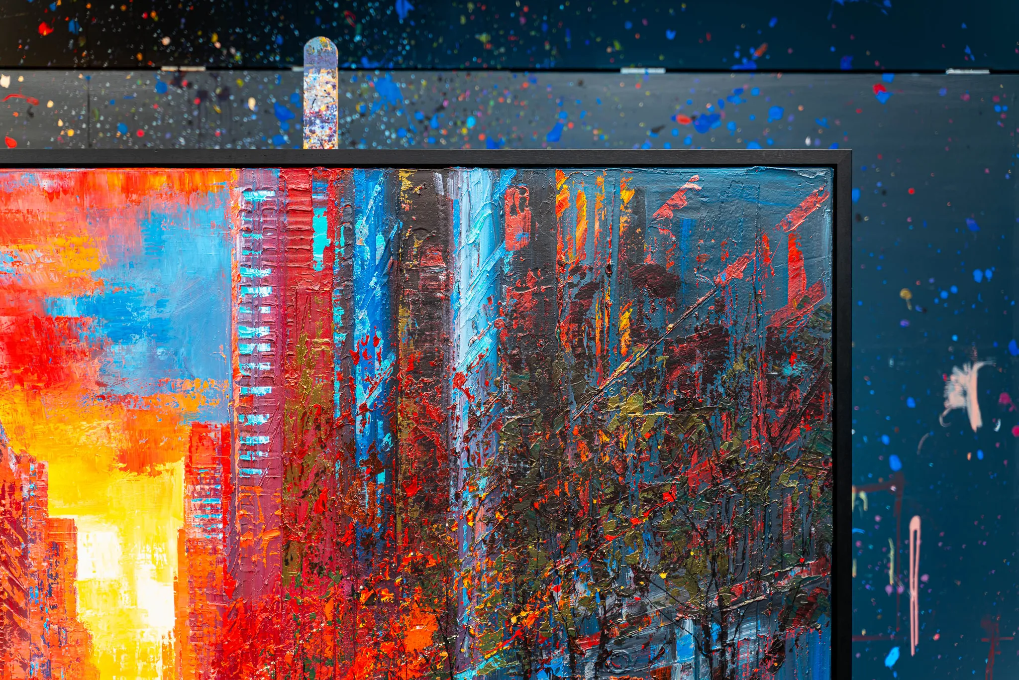 Close-up of NY Ablaze, an original mixed media painting by Paul Kenton, showing thick textured paint in fiery orange and red towers against blue, with a dark, dense street below.