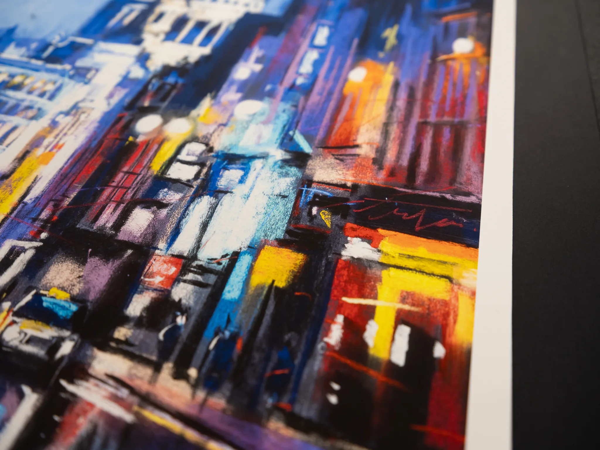 Close-up of St Paul's Star, a limited edition print by Paul Kenton, showing a textured city street at dusk with bold blue, purple, red and yellow strokes and glowing lamps.