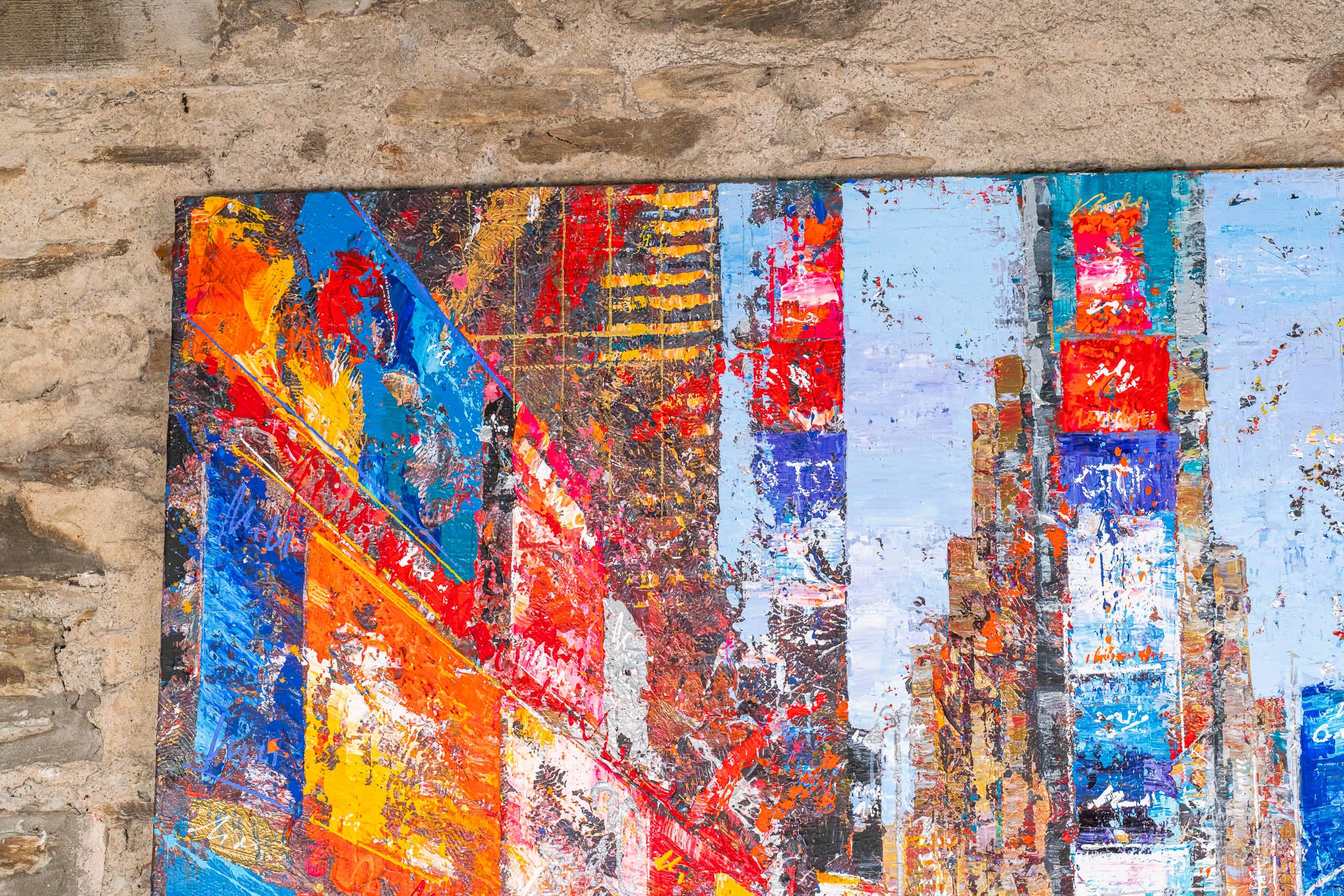 Close-up of Steps Through Times Square, an original mixed media painting by Paul Kenton: thick, scraped layers of orange, red and blue paint form jagged skyscrapers against pale blue, with flecks of metallic gold.
