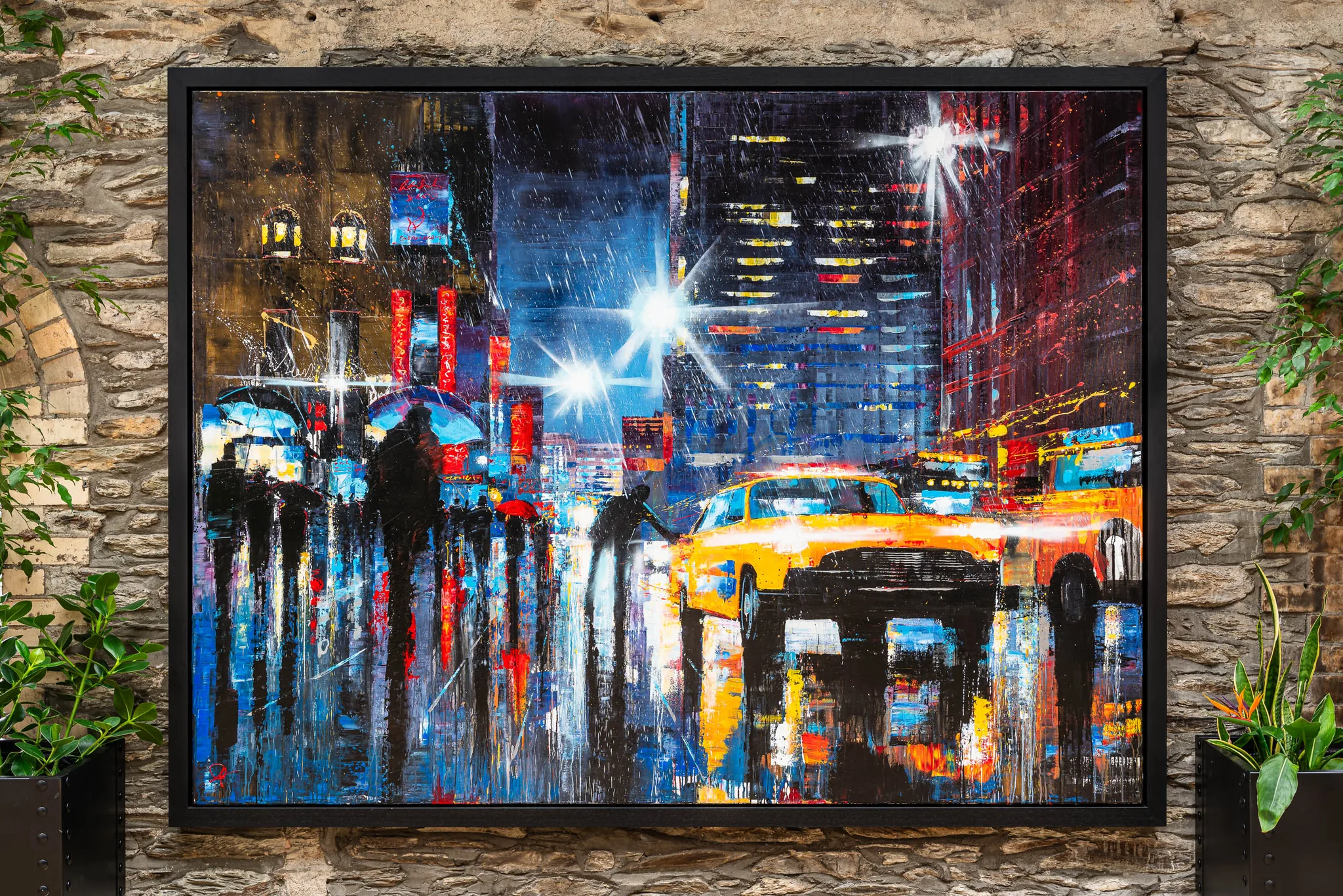 Taxi Dash, an original painting by Paul Kenton hung on a stone wall: a rain-soaked New York street at night, with a yellow taxi, dark umbrella-carrying figures and bright blue and red city lights.