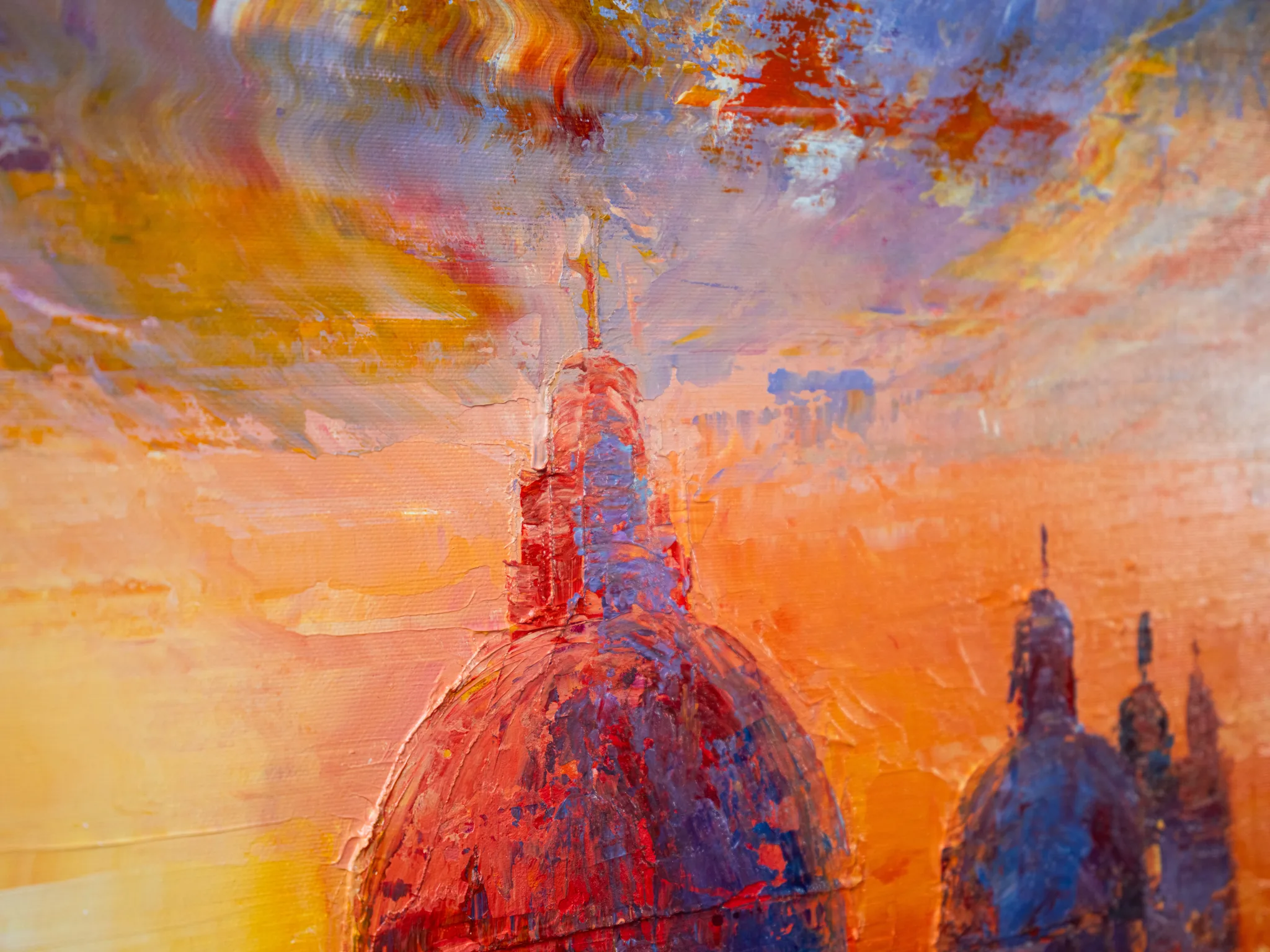 Close-up detail of Venice Ablaze, an original painting by Paul Kenton, showing thick impasto brushwork on domes and spires in red and violet against a glowing orange sky.