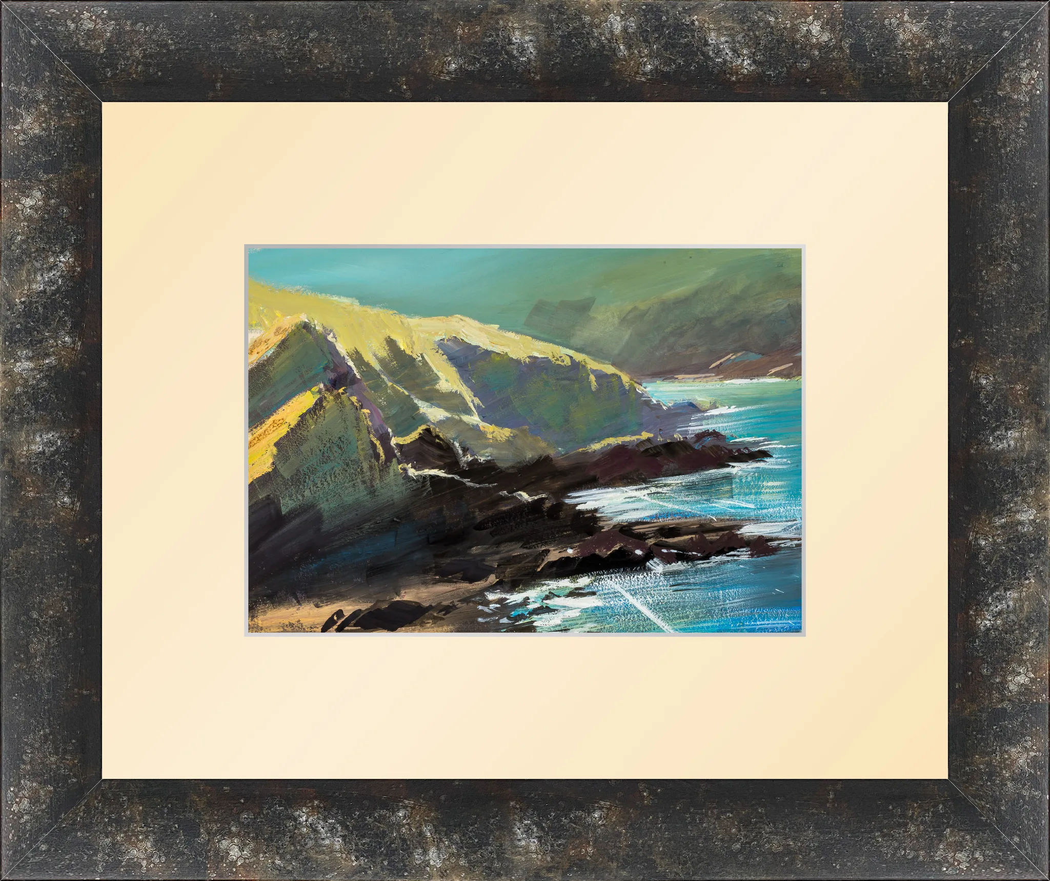 Ilfracombe Sparkle, gouache on paper in a dark distressed wooden frame with a wide cream mount: sunlit green-yellow cliffs slope into dark rocks, with turquoise sea glinting beneath a teal sky.