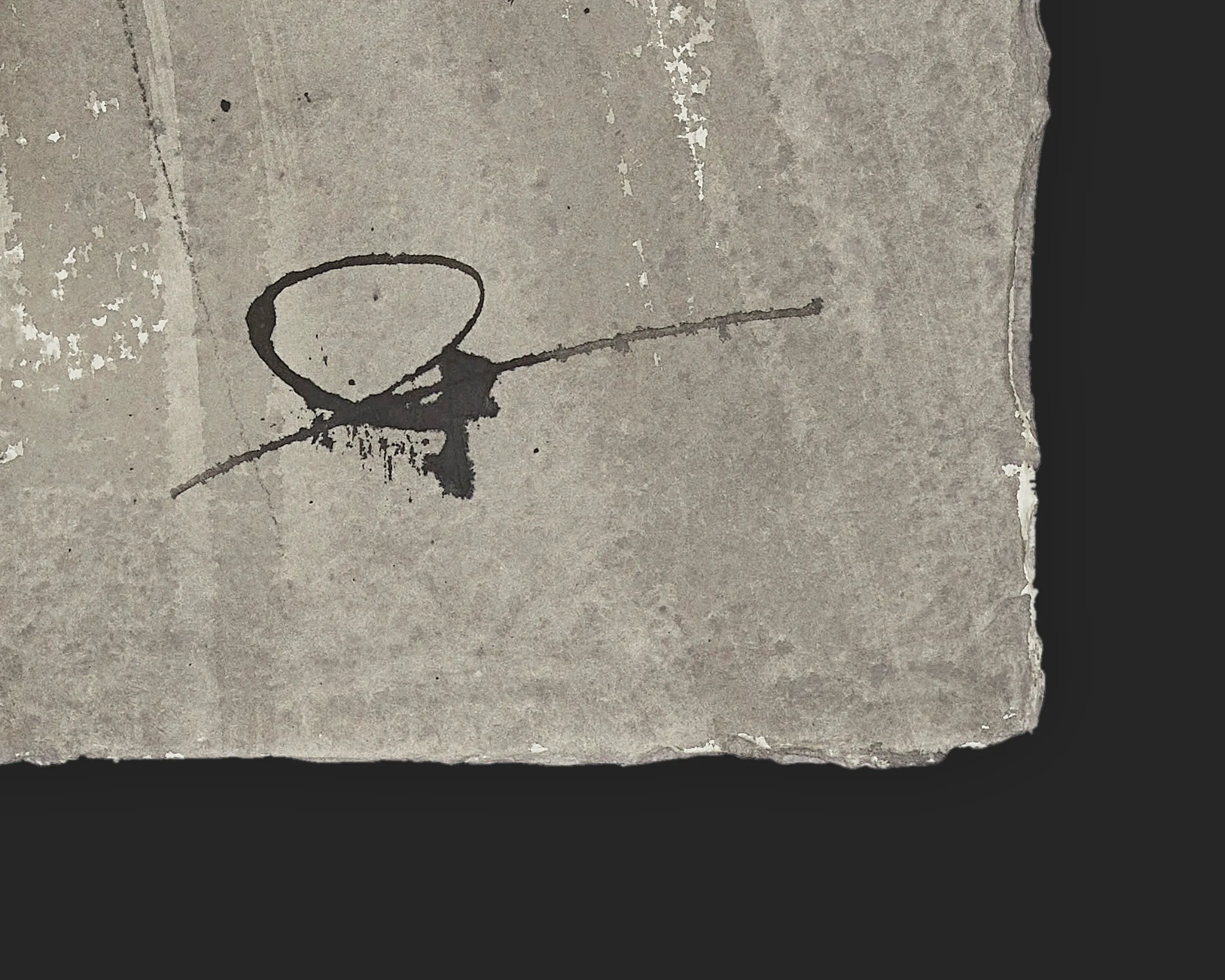 Close-up detail of Urban Contours, an original ink painting by Paul Kenton: a dark, looping ink mark with a trailing line on weathered grey paper, a corner edge visible against black.