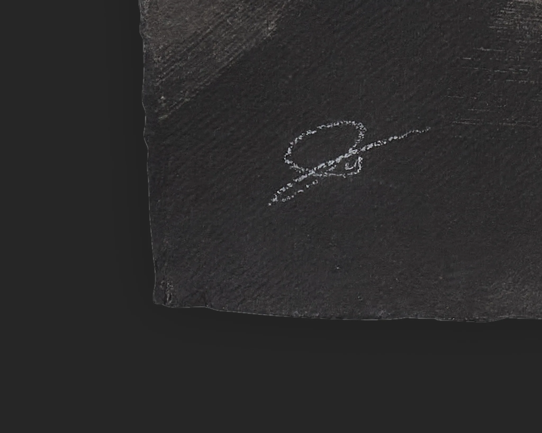 Close-up of the artist's pale signature in the corner of Sidewalk Shadows, an original ink painting on Indian paper, with faint textured strokes on dark paper.