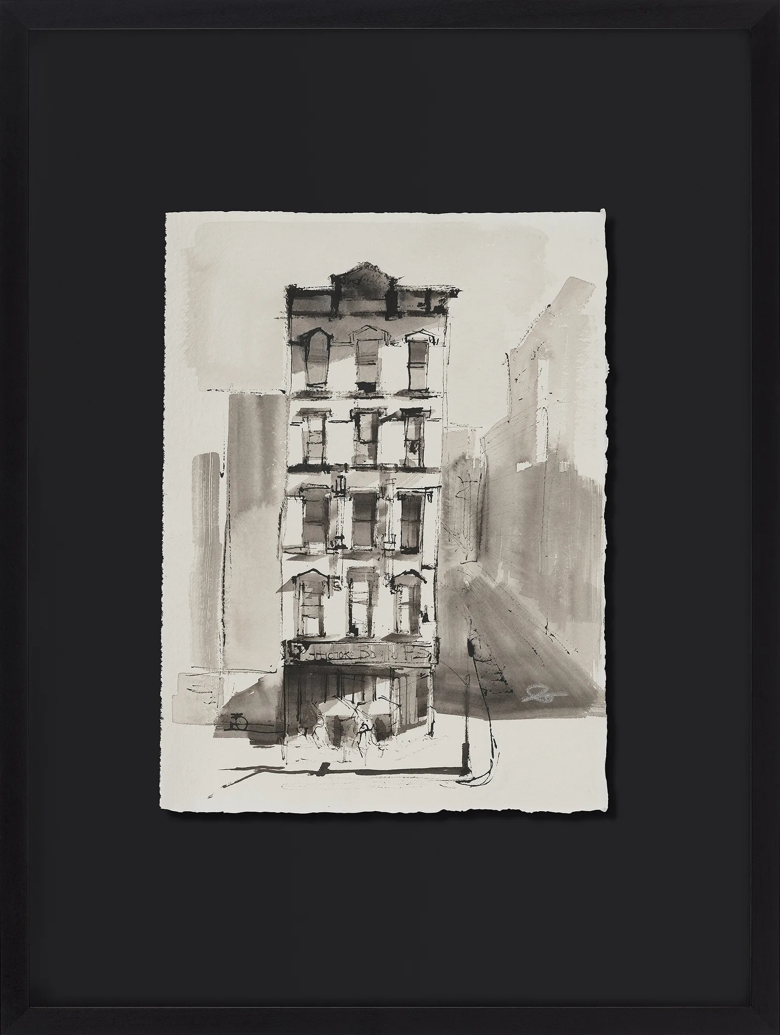 Facade In Light, an original ink painting by Paul Kenton on Indian paper, shown in a black frame: a tall grey-washed brick building with a shopfront, set against a shaded side street.
