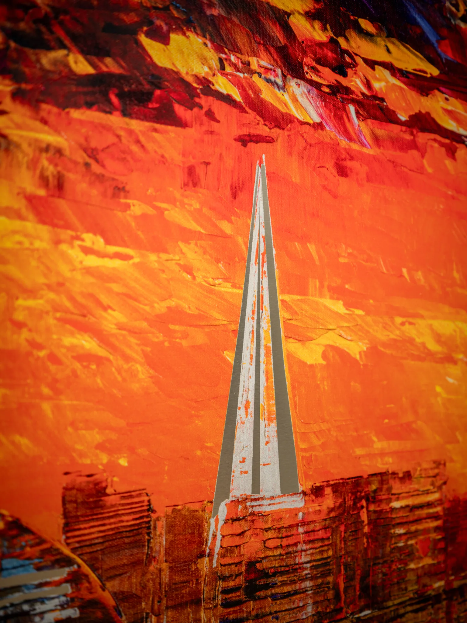 Close-up of Currents of Light, a limited edition print by Paul Kenton, showing a thin grey and white spire rising against thick orange and yellow brushstrokes with a dark red sky above and a textured London skyline below.