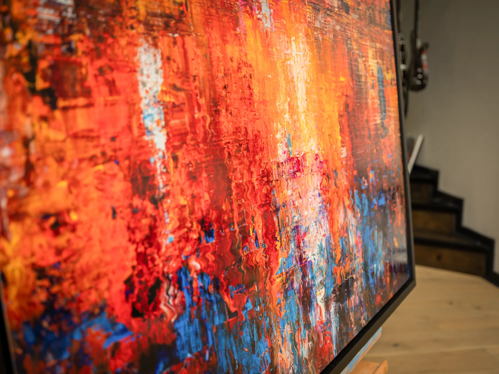 Close-up of Currents of Light, a limited edition print by Paul Kenton, showing textured vertical streaks of red, orange and gold with flecks of blue and white.