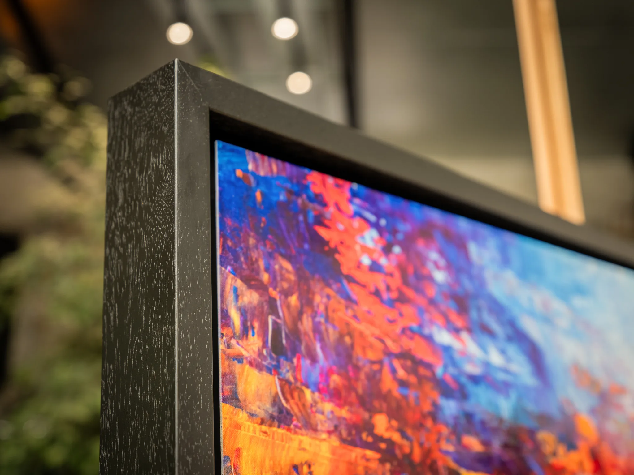Close-up of Currents of Light, a limited edition print by Paul Kenton, showing bold red, orange and blue brushwork in a dark grey frame.