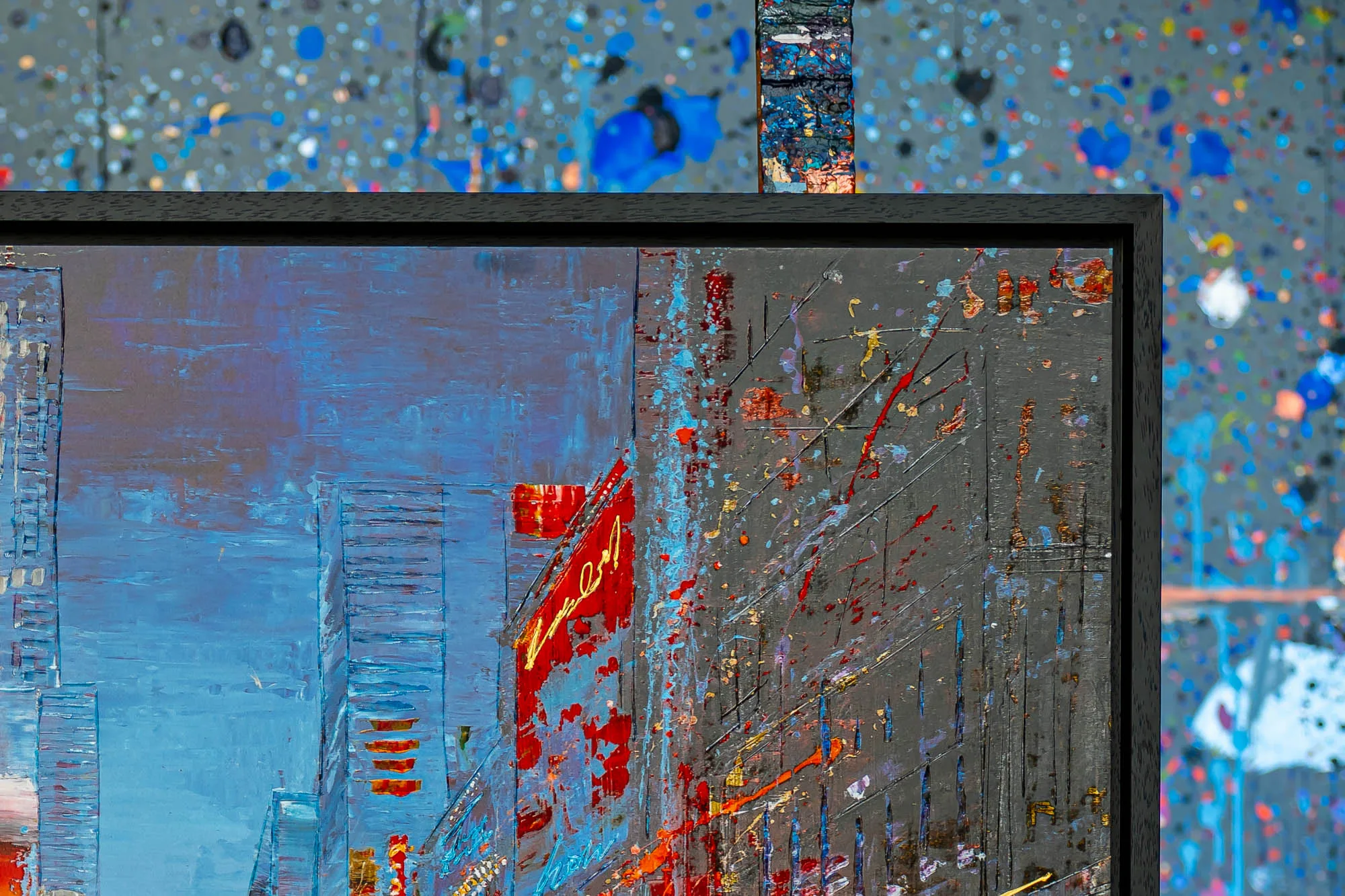 Close-up of Empire City Spectrum, showing thick textured paint on a blue cityscape with pale building forms, a red and gold sign, and a dark grey area splattered with red, orange and blue marks.