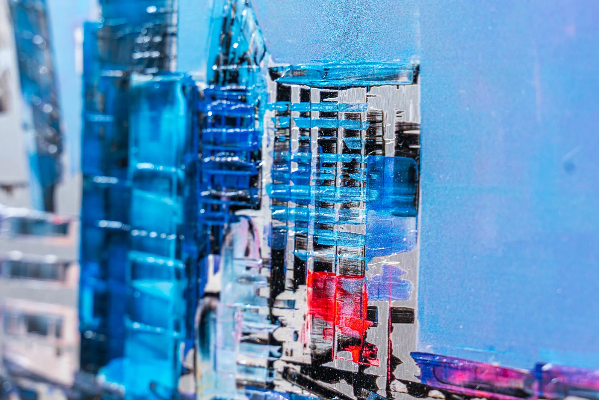Close-up of London Reflects, a limited edition print by Paul Kenton, showing textured blue towers and a flash of red brushwork against a grey cityscape.