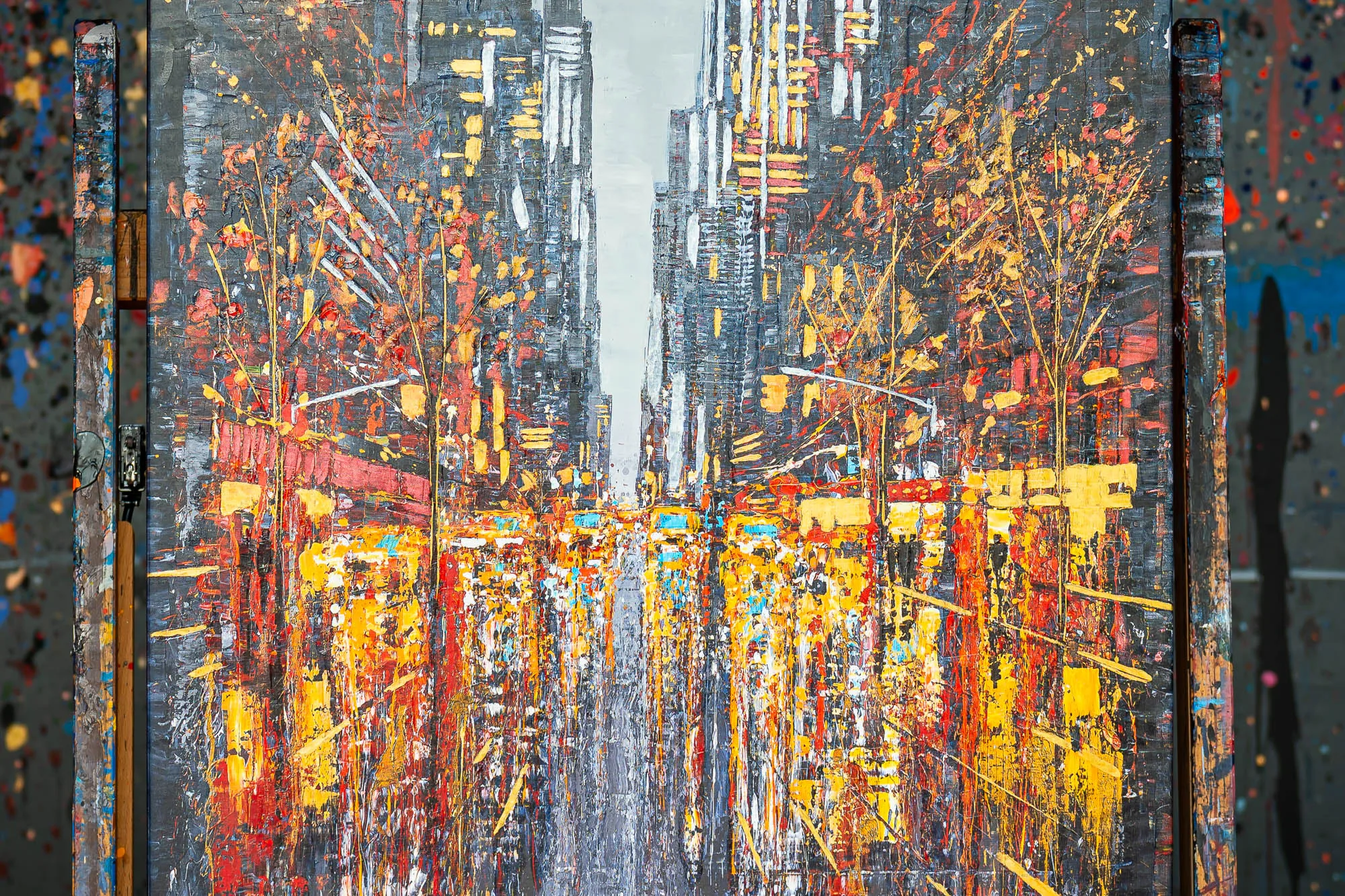 Close-up of New York Serenade, an embellished giclée print on canvas by Paul Kenton, showing a yellow and red city avenue with thick, textured paint and tall grey towers.