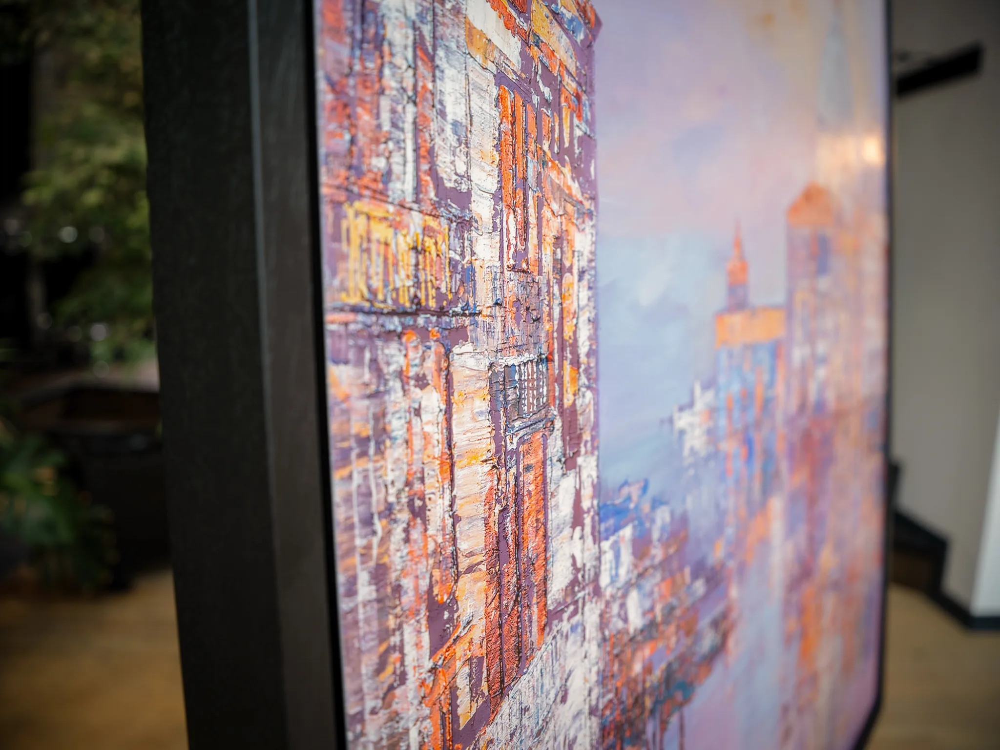Close-up of Opalescent Venice, a limited edition print by Paul Kenton, showing textured buildings in orange, cream and lilac under a pale blue sky, with a dark frame edge.