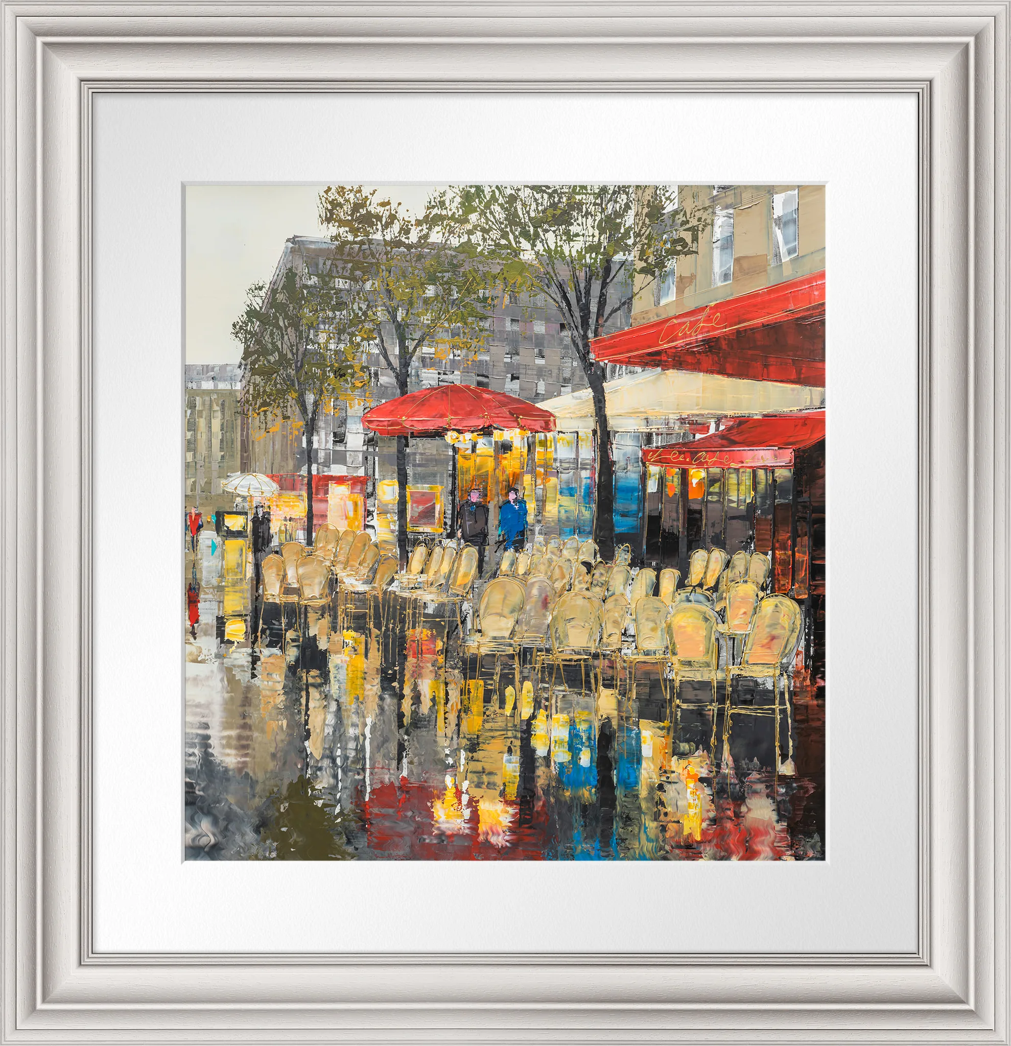 Parisien Life, a limited edition print by Paul Kenton, shown in a silver frame with white mount: a rain-soaked Paris café terrace with red awnings, empty bistro chairs and reflections on wet pavement.