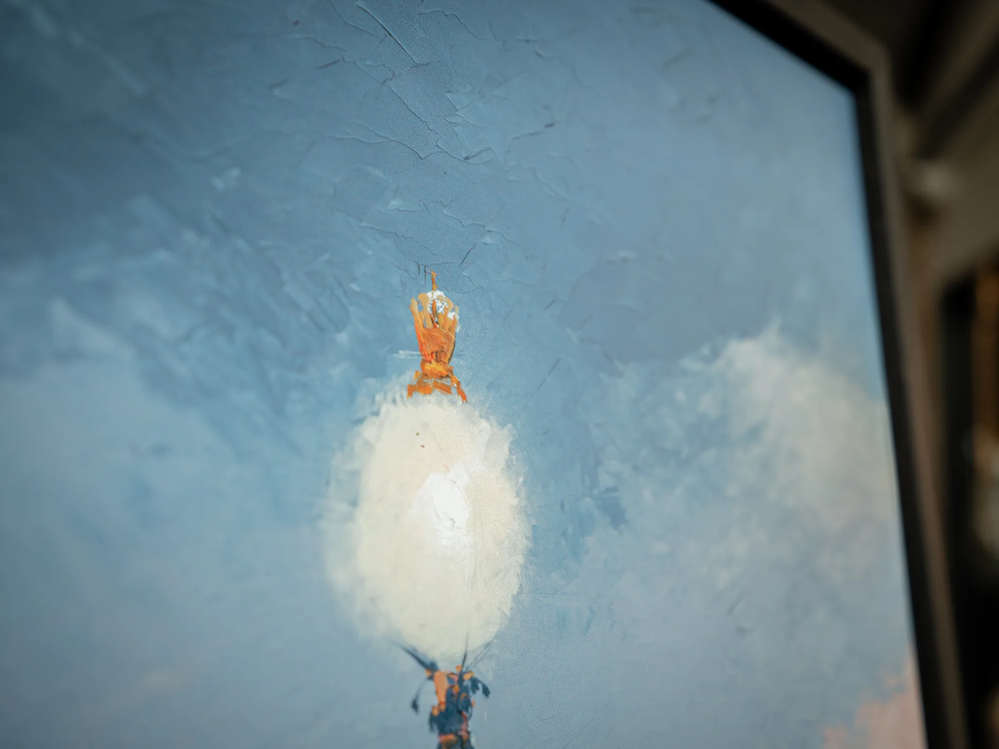 Close-up of Thames Light, a limited edition print by Paul Kenton, showing a textured pale blue sky with a white, cloud-like balloon and an orange and blue basket below.