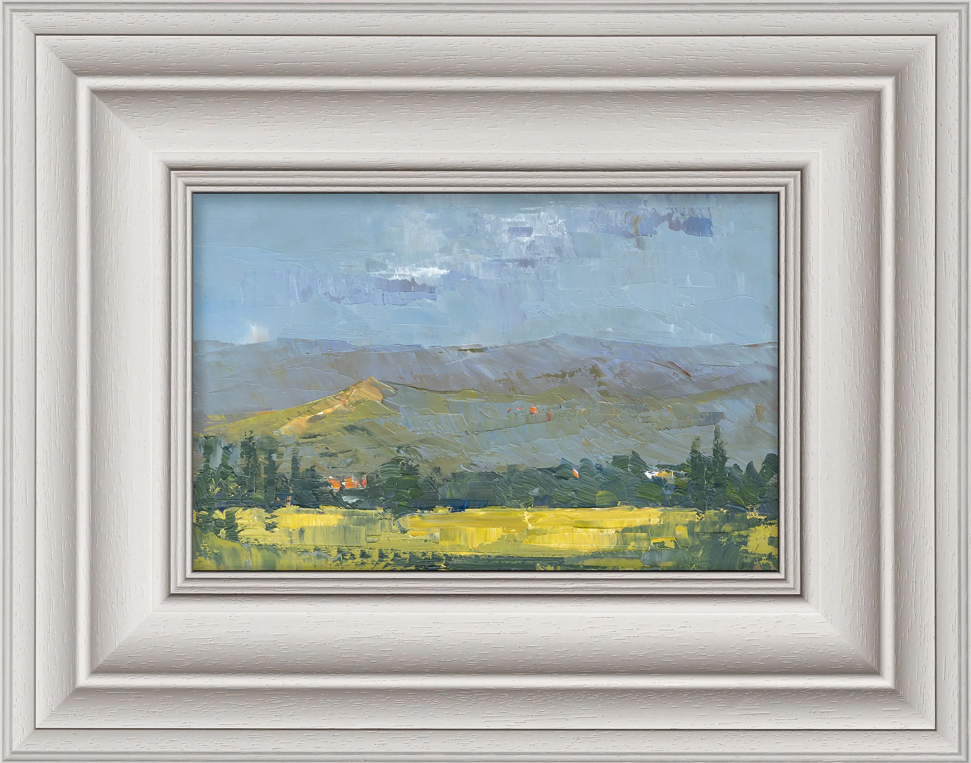 Italian Vista, an original oil painting by Paul Kenton in a wide cream frame: rolling hills under a pale blue sky, with dark green trees and a bright yellow field in the foreground.