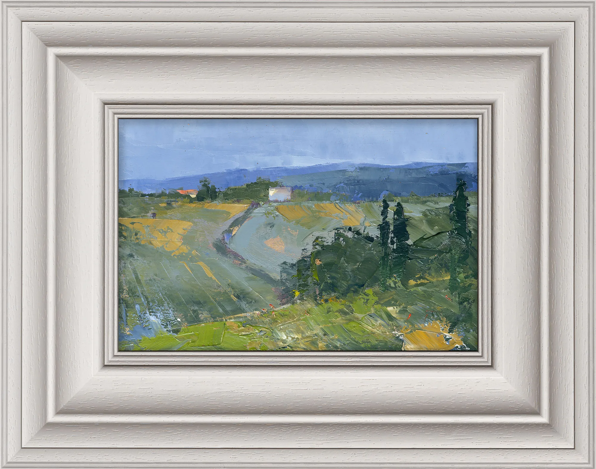 Italian View, an original oil painting by Paul Kenton, in a wide cream frame: a textured Tuscan landscape of green and gold fields, cypress trees and a pale blue sky.