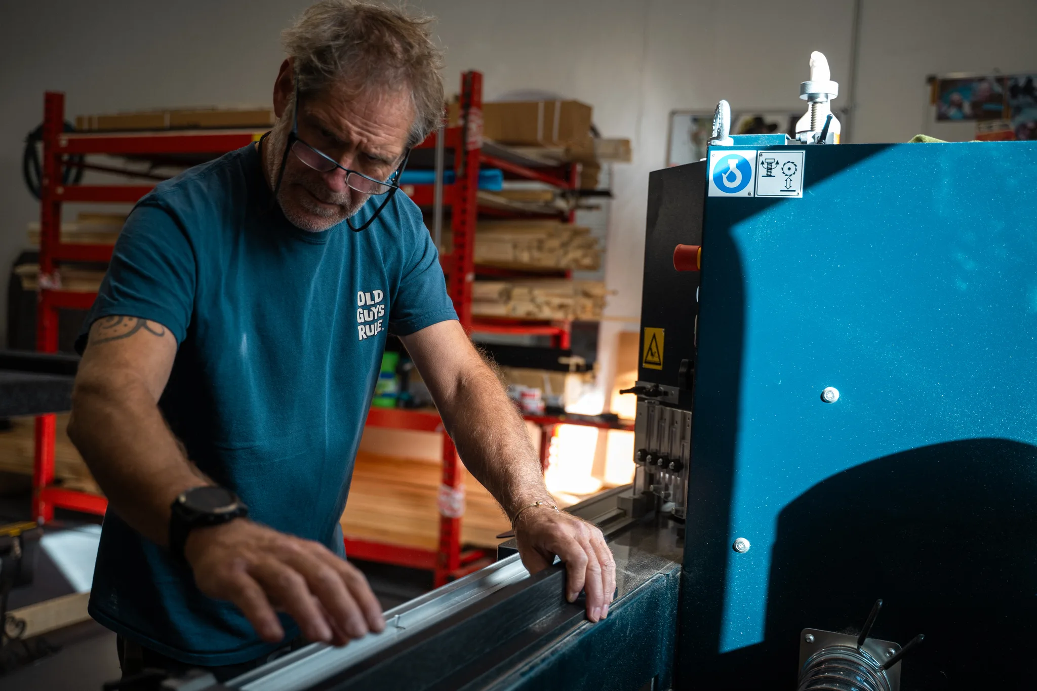 Alan joining a length of black moulding at the corner joiner, with racks of moulding behind him