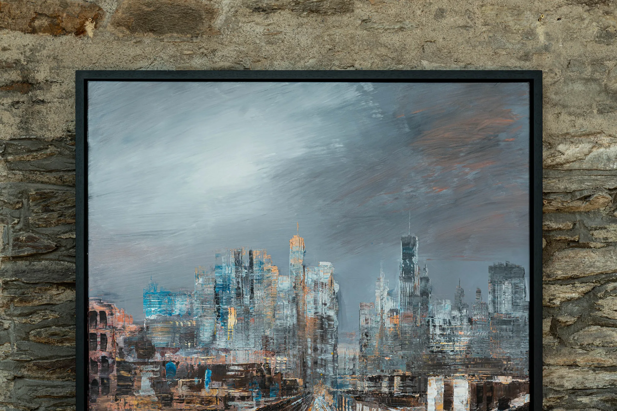Close-up of New York Groove, an original mixed media painting by Paul Kenton, showing a textured grey skyline under a brooding sky with glints of blue and amber on the towers.