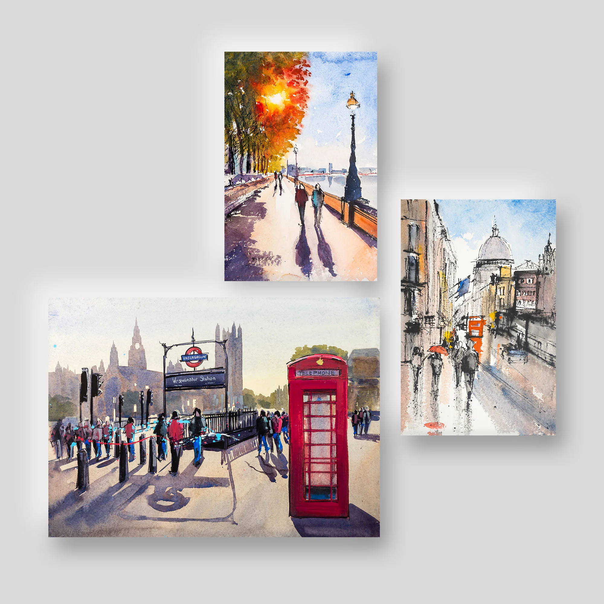London Watercolour and Ink, a print collection set by Paul Kenton: three London scenes, a red telephone box beside Westminster Underground station, an autumn riverside path, and a rainy street near St Paul's.