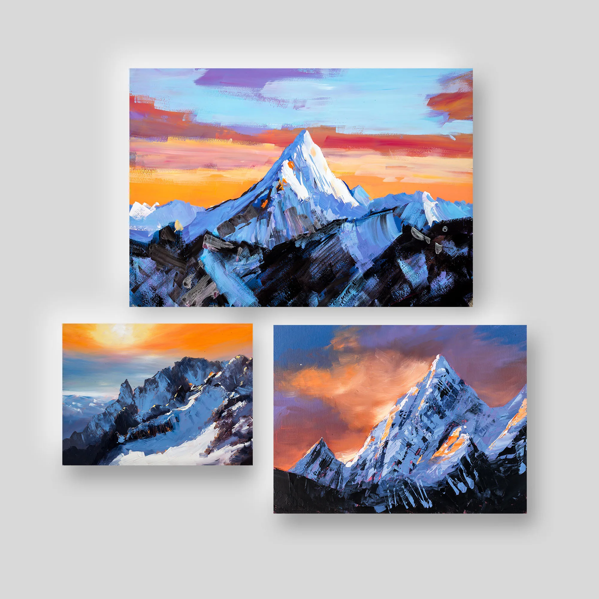Mountainscapes, a print collection set by Paul Kenton: three textured mountain scenes with snow-capped peaks against orange, violet and ice-blue sunrise and sunset skies.